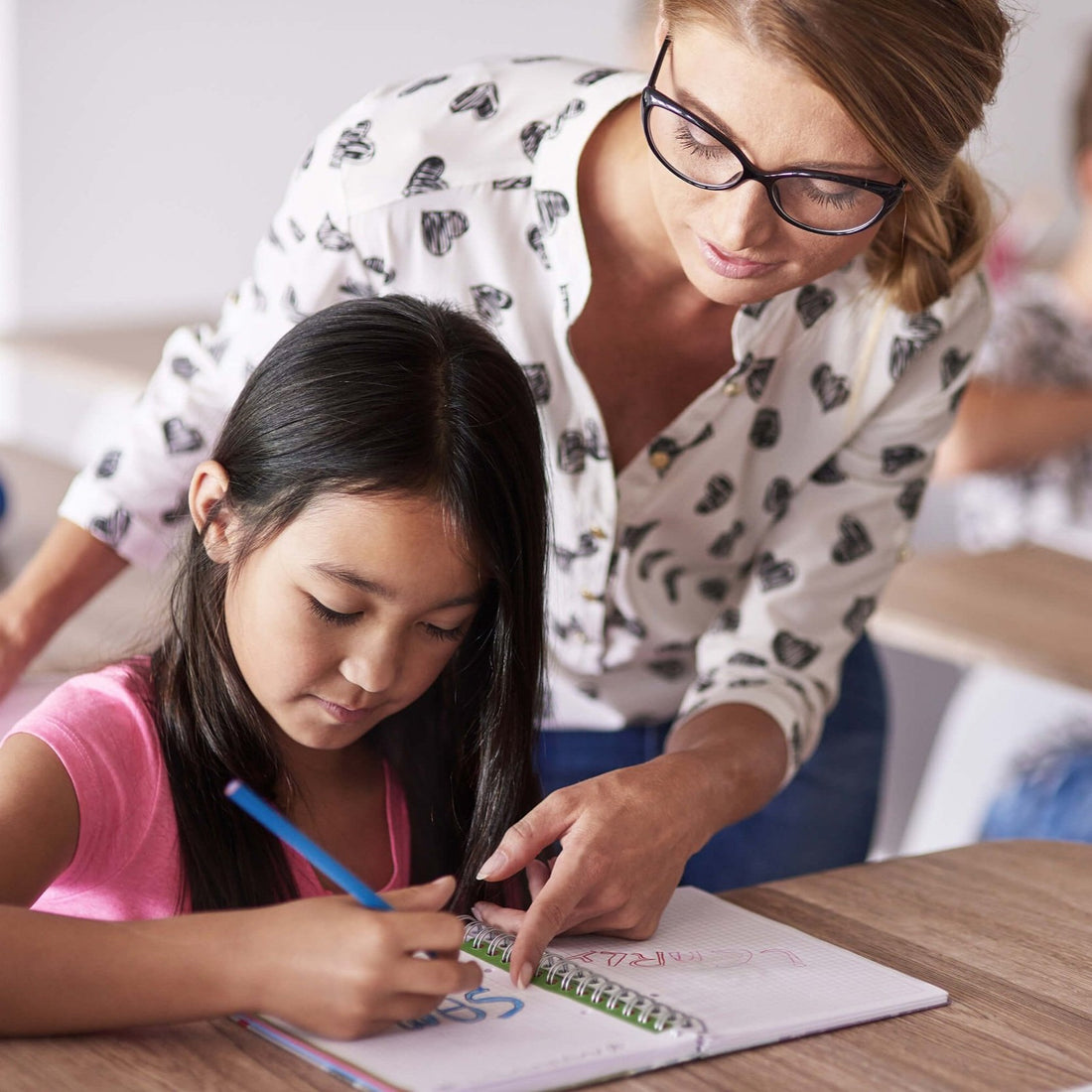 Professeur aidant un élève dans une classe